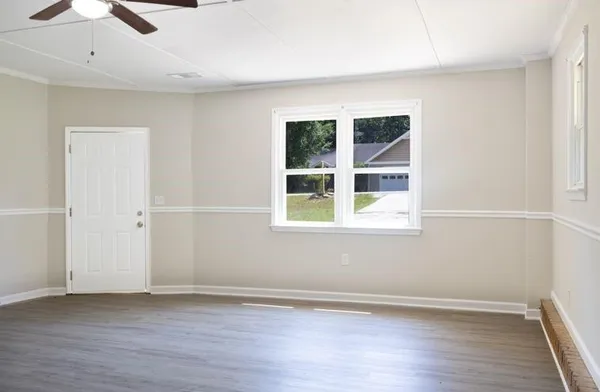 an empty room with a window and wooden floor
