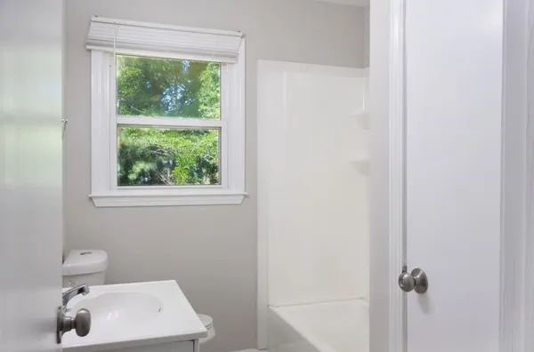 a bathroom with a sink a toilet and a window