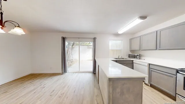 a kitchen with wooden floor and white appliances