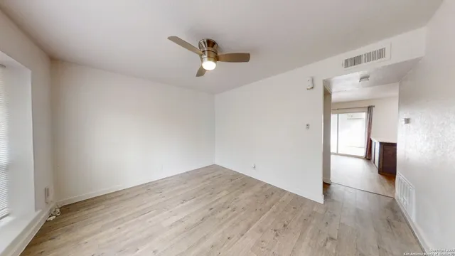 a view of a room with wooden floor and white walls