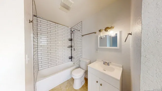 a bathroom with a toilet sink vanity tub and mirror