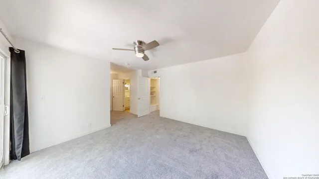 a view of a livingroom with a ceiling fan and window
