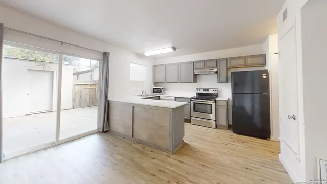 a kitchen with a refrigerator a stove top oven and kitchen island