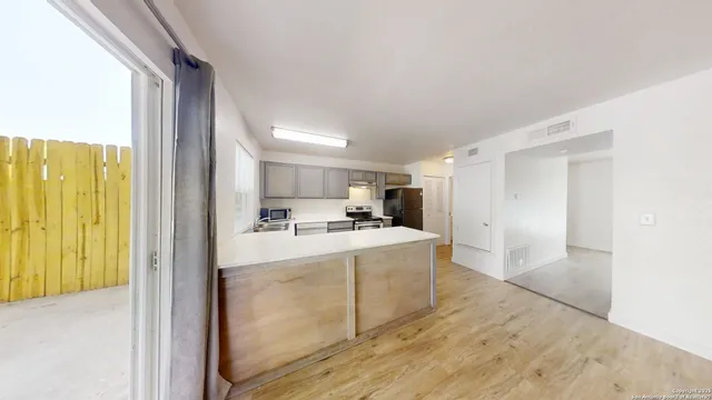a large white kitchen with a stove a sink and a refrigerator