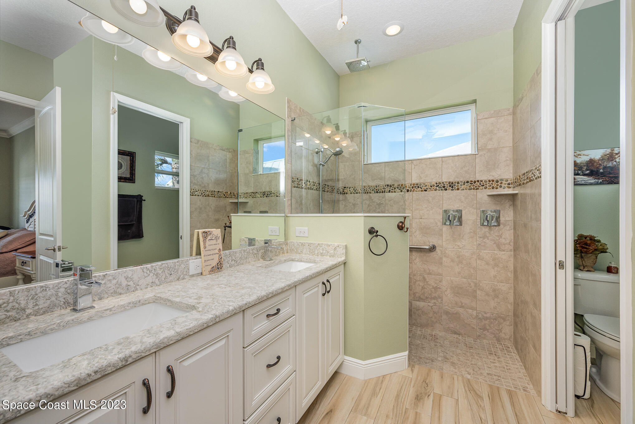 3850 Alamanda Key Drive Melbourne, FL 32901 - Photo 15 of 44 a bathroom with a granite countertop shower a sink and a mirror