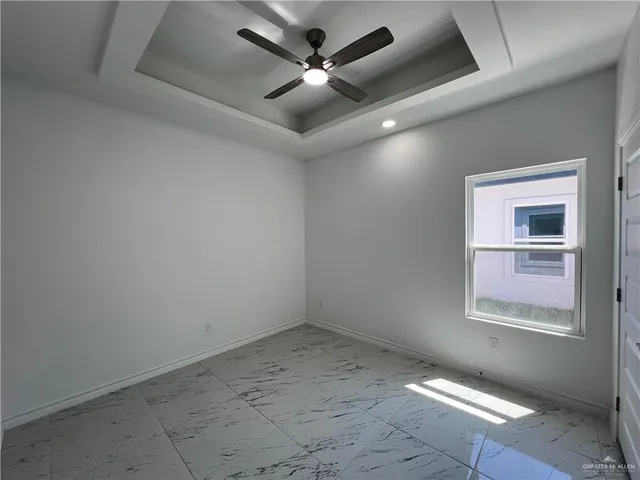 an empty room with a ceiling fan and window