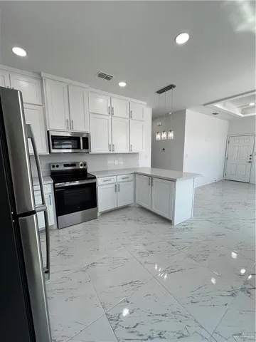 a large kitchen with cabinets and stainless steel appliances