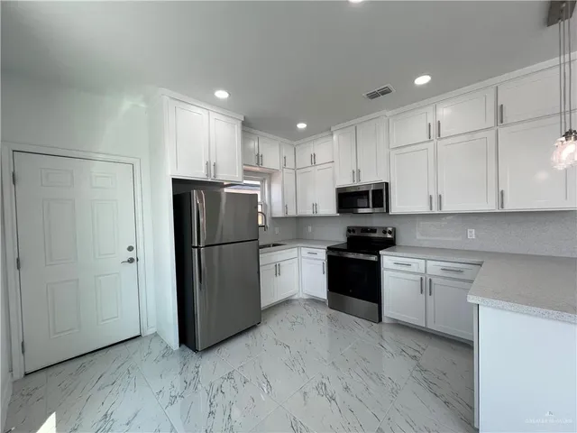 a kitchen with a refrigerator and a stove top oven