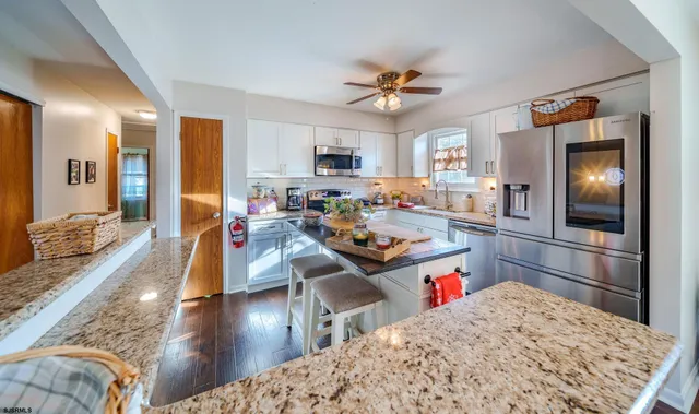 a living room with stainless steel appliances kitchen island granite countertop furniture and a kitchen view
