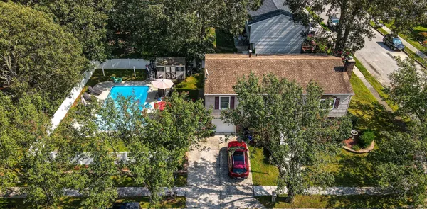 an aerial view of a house with a yard and large trees