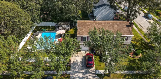 an aerial view of a house with a yard and large trees