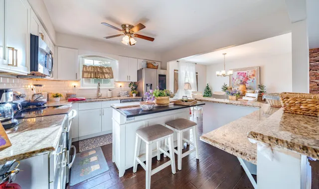 a living room with granite countertop furniture kitchen view and a chandelier