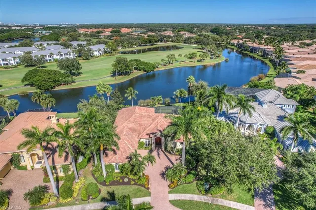 an aerial view of a house with a yard and lake view