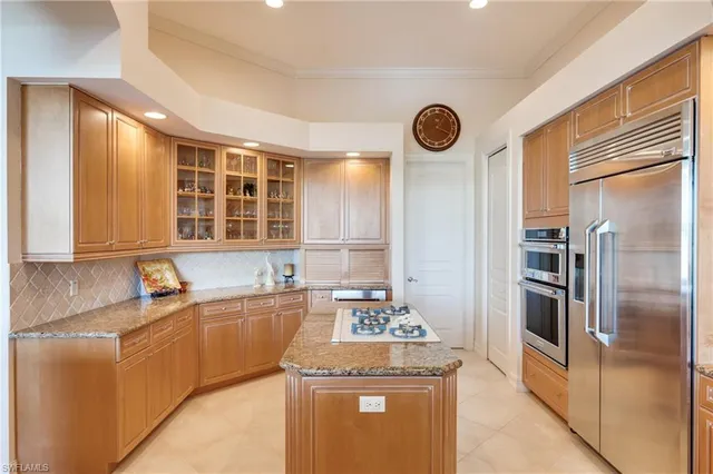 a kitchen with stainless steel appliances granite countertop a sink and a refrigerator