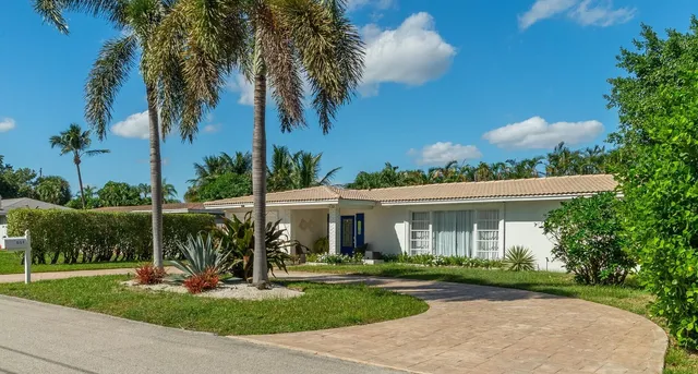 a view of a house with a yard and potted plants
