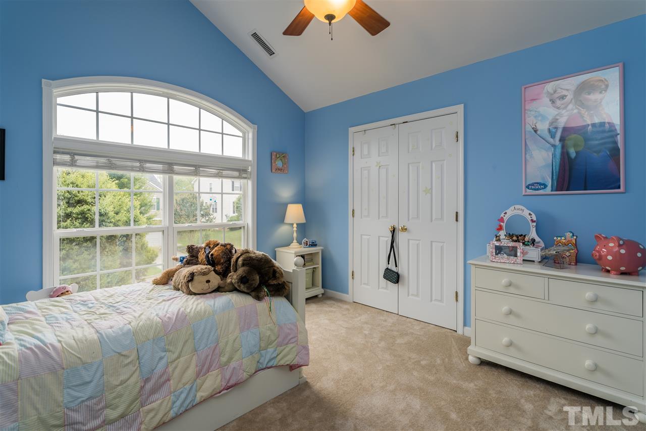 228 Mickleson Ridge Drive Raleigh, NC 27603 - Photo 13 of 25 a bedroom with a bed and a chandelier fan