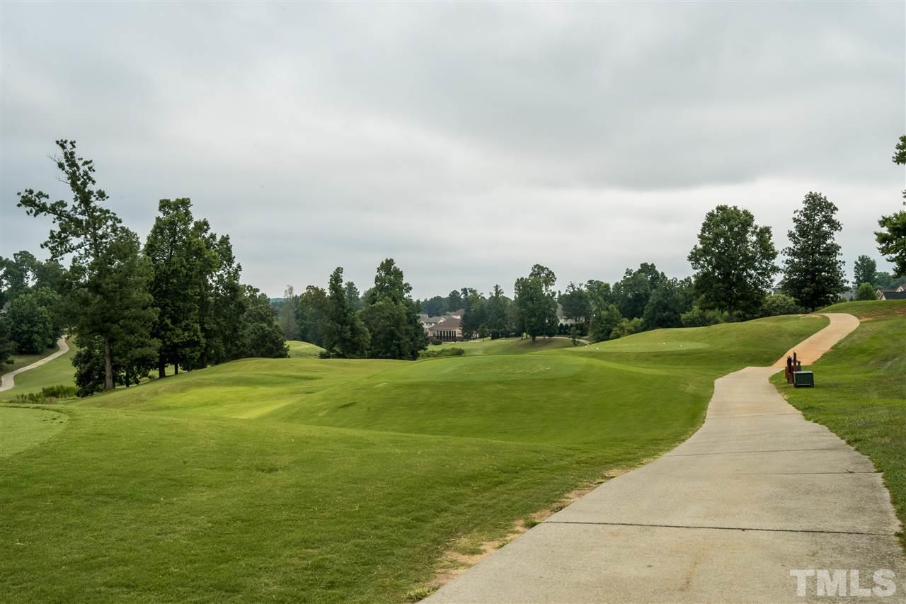 228 Mickleson Ridge Drive Raleigh, NC 27603 - Photo 23 of 25 a view of a golf course with a lake