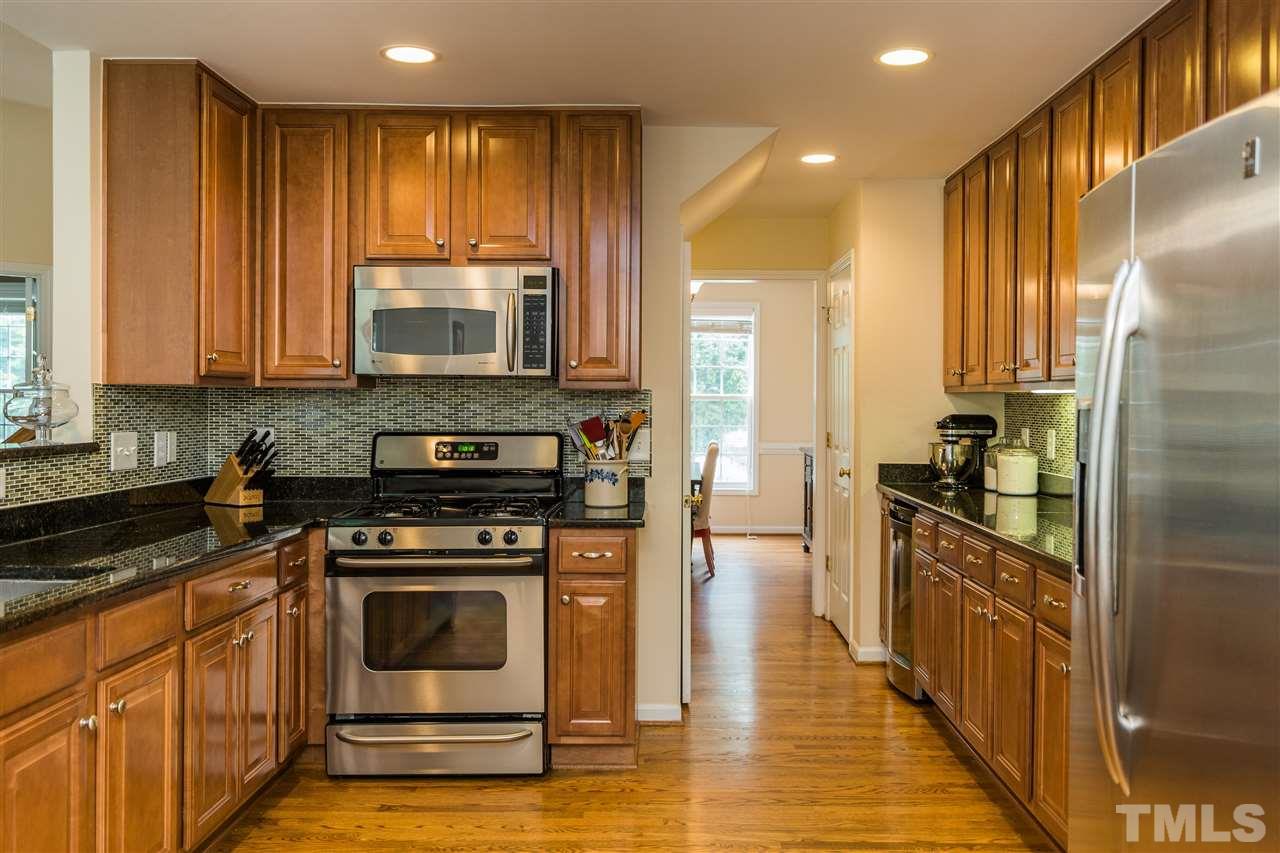 228 Mickleson Ridge Drive Raleigh, NC 27603 - Photo 7 of 25 a kitchen with a stove a sink and a refrigerator