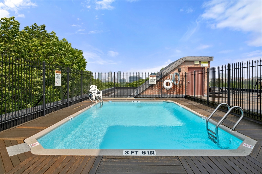 135 Pleasant Street, Unit 403 Brookline, MA 02446 - Photo 15 of 18 a view of a swimming pool with a bench and trees
