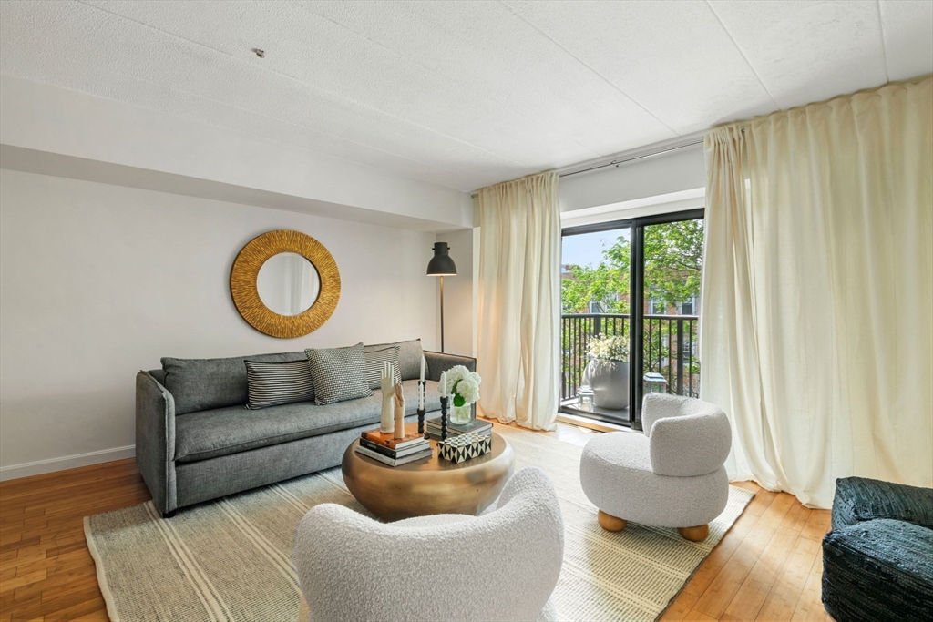 135 Pleasant Street, Unit 403 Brookline, MA 02446 - Photo 2 of 18 a living room with furniture and a large window