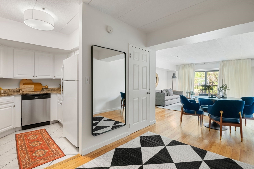 135 Pleasant Street, Unit 403 Brookline, MA 02446 - Photo 3 of 18 a living room with furniture and a rug