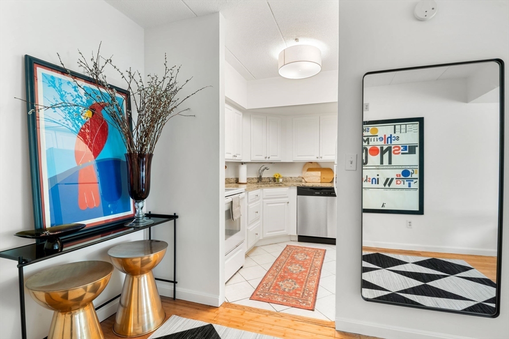 135 Pleasant Street, Unit 403 Brookline, MA 02446 - Photo 4 of 18 a living room with furniture and a wall painting