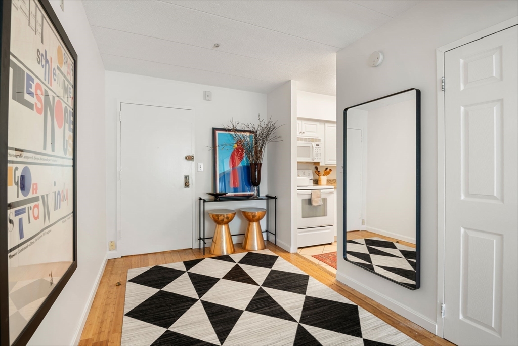 135 Pleasant Street, Unit 403 Brookline, MA 02446 - Photo 5 of 18 a room with a black white checkered floor with a table and chairs