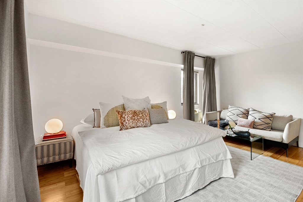 135 Pleasant Street, Unit 403 Brookline, MA 02446 - Photo 8 of 18 a bedroom with a bed and wooden floor