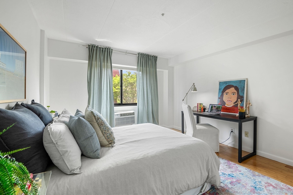 135 Pleasant Street, Unit 403 Brookline, MA 02446 - Photo 10 of 18 a bedroom with a bed and a table in it