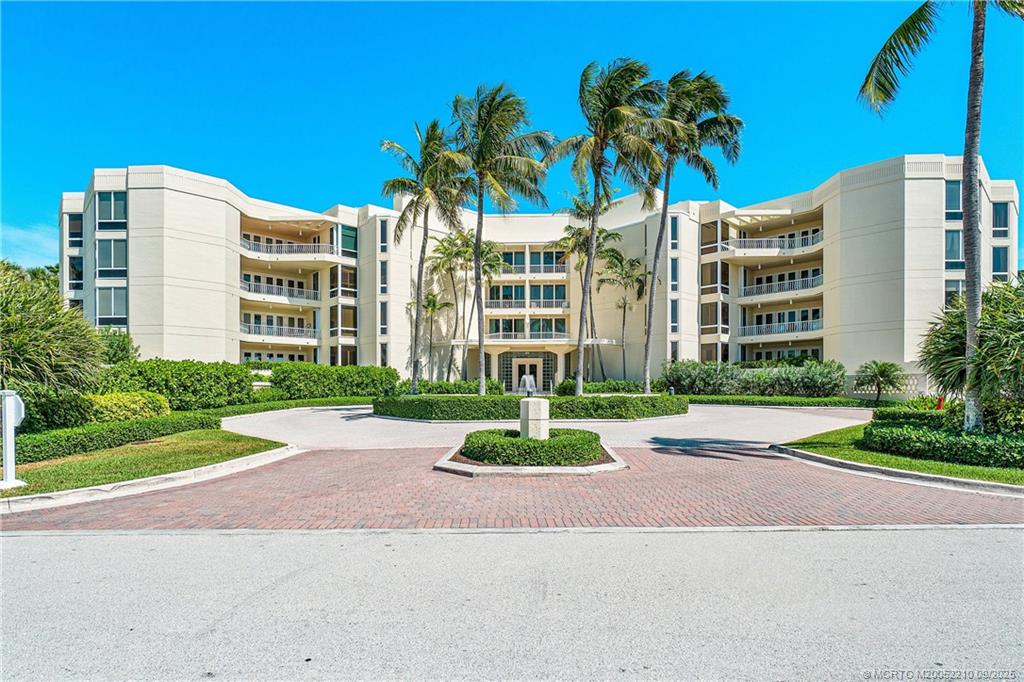 3001 Southeast Island Point Lane, Unit 14 Stuart, FL 34996 - Photo 26 of 38 a front view of multi story residential apartment building with yard and green space