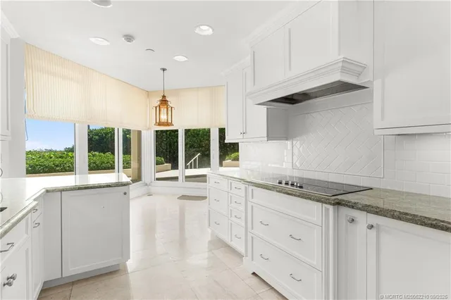 a kitchen with granite countertop white cabinets and a sink