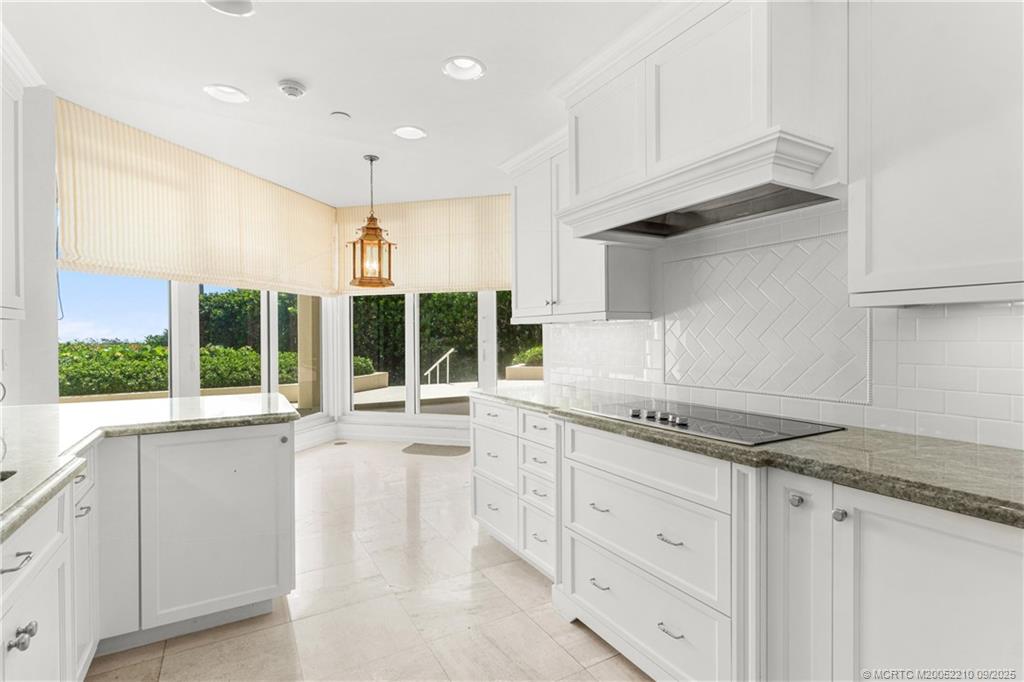 3001 Southeast Island Point Lane, Unit 14 Stuart, FL 34996 - Photo 4 of 38 a kitchen with granite countertop white cabinets and a sink