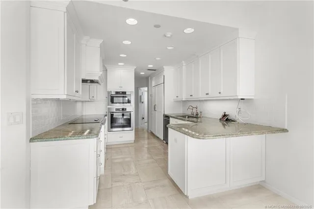 a kitchen with a sink a stove top oven and cabinets