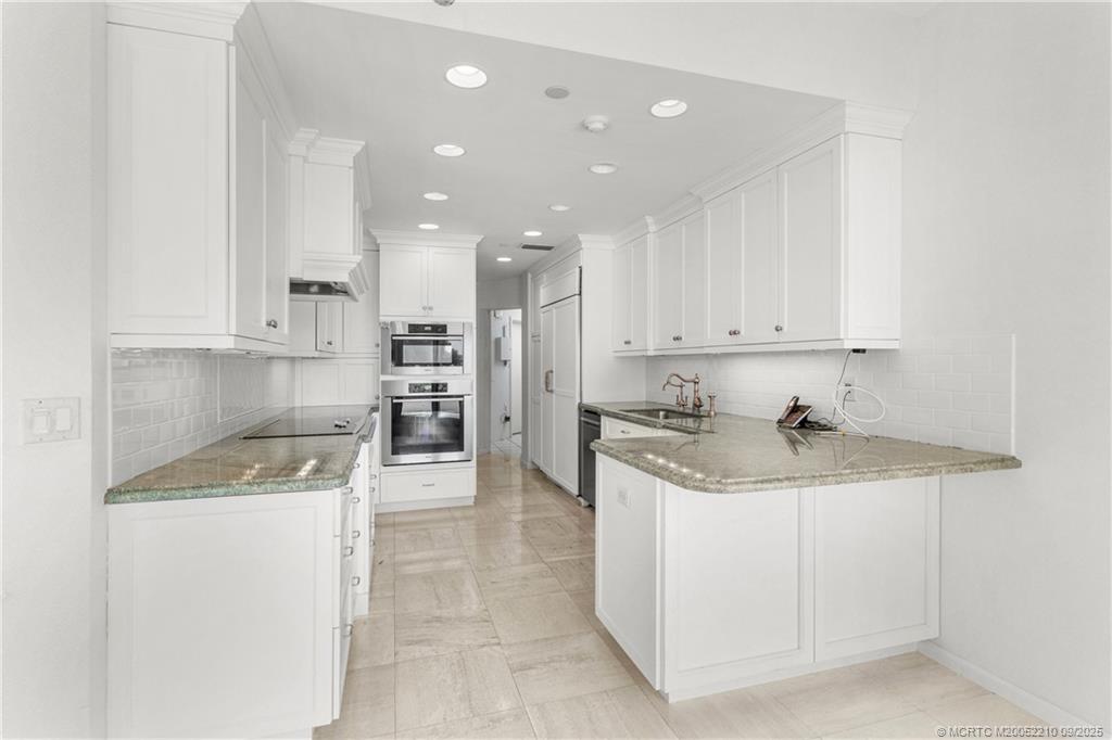 3001 Southeast Island Point Lane, Unit 14 Stuart, FL 34996 - Photo 6 of 38 a kitchen with a sink a stove top oven and cabinets