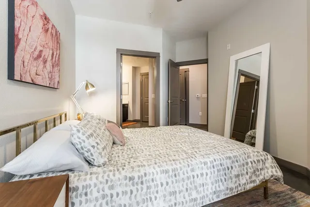 a bedroom with a bed and a painting on the wall