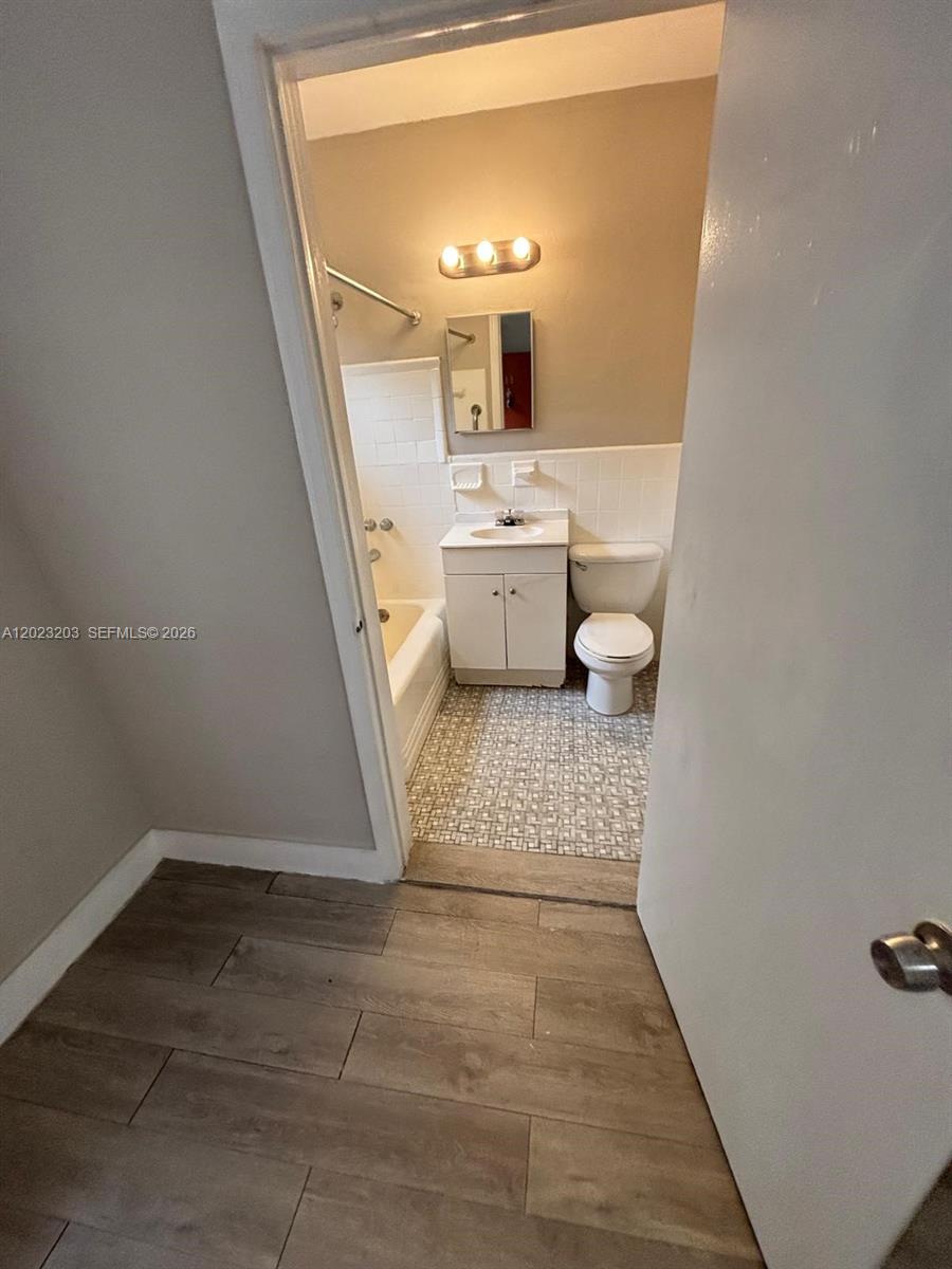 520 Southwest 4th Street, Unit 11 Miami, FL 33130 - Photo 3 of 7 a bathroom with a sink a toilet and a mirror