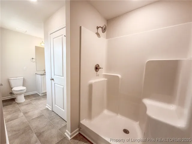 a bathroom with a granite countertop bathtub shower and toilet