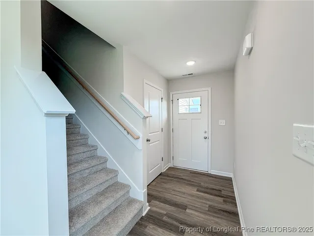 a view of a hallway to an entryway with wooden floor