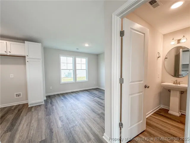 a view of a room with wooden floor and bathroom view