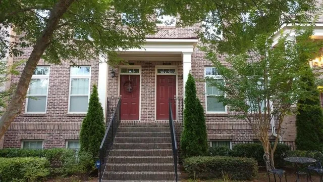 a view of a brick house with a large windows and a large tree