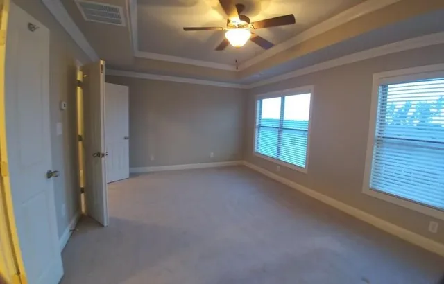 en empty room with windows and ceiling fan