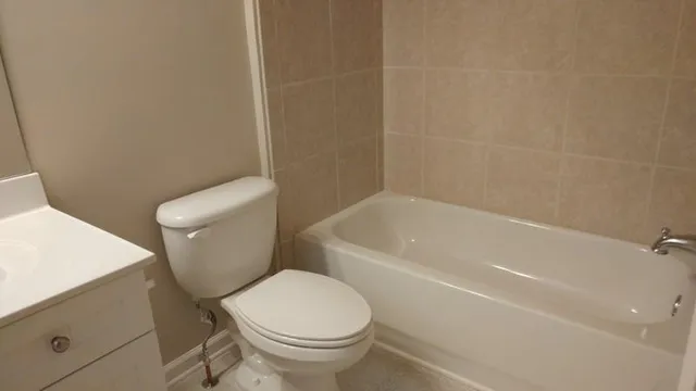 a white toilet sitting next to a bath tub