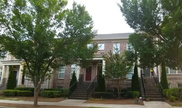 a front view of a house with a tree