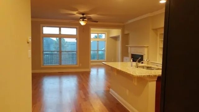 a view of a livingroom with wooden floor and a ceiling fan