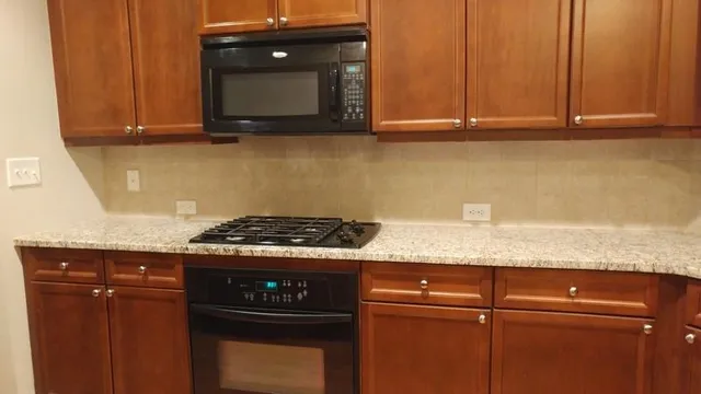 a kitchen with granite countertop cabinets and black appliances