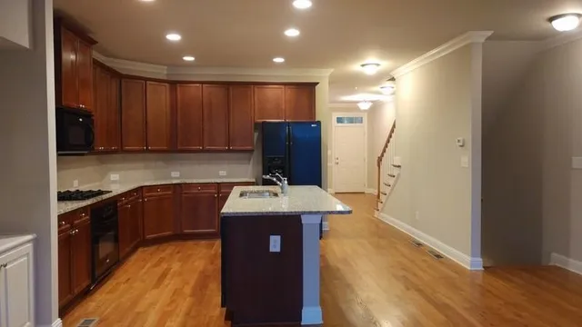 a kitchen with a refrigerator a sink and wooden floor