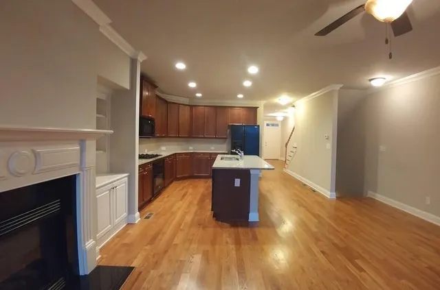 a large kitchen with stainless steel appliances granite countertop a large counter top a stove and a wooden floors