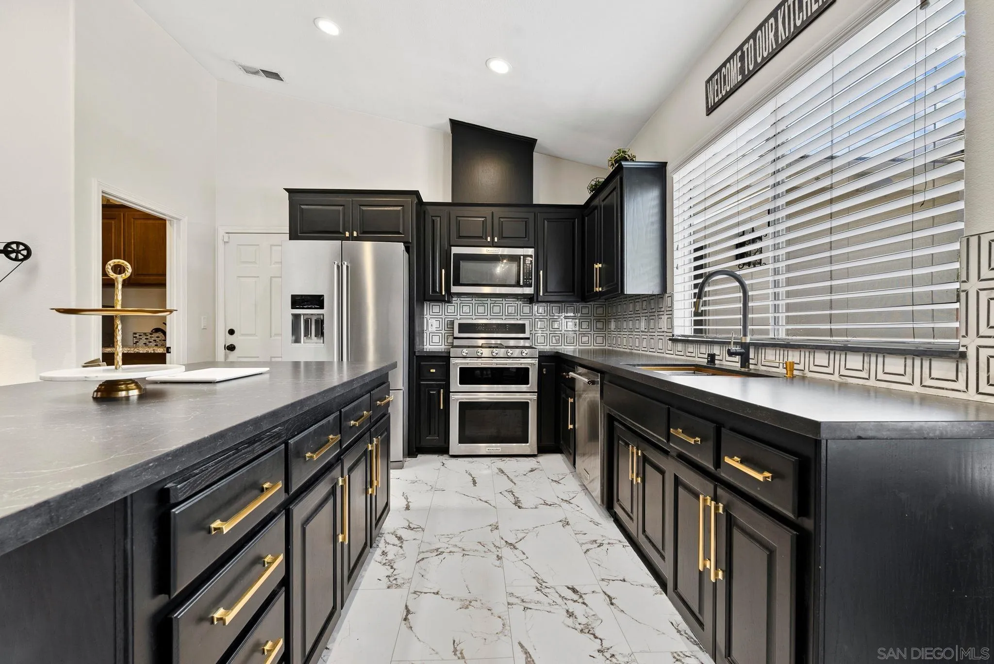 624 Rowley Way Ramona, CA 92065 - Photo 15 of 54 a kitchen with stainless steel appliances a sink dishwasher a stove top oven a refrigerator with wooden cabinets and floor
