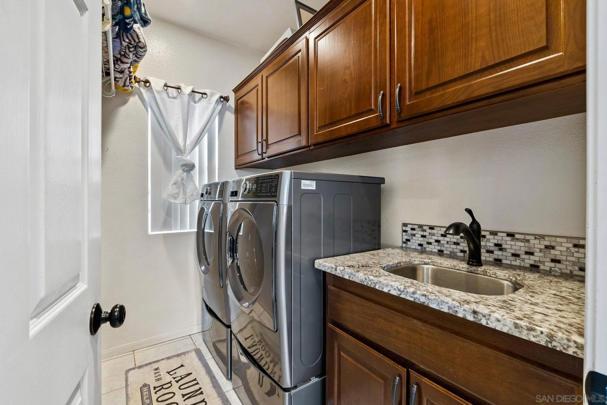 624 Rowley Way Ramona, CA 92065 - Photo 26 of 54 a bathroom with a sink a washer and dryer