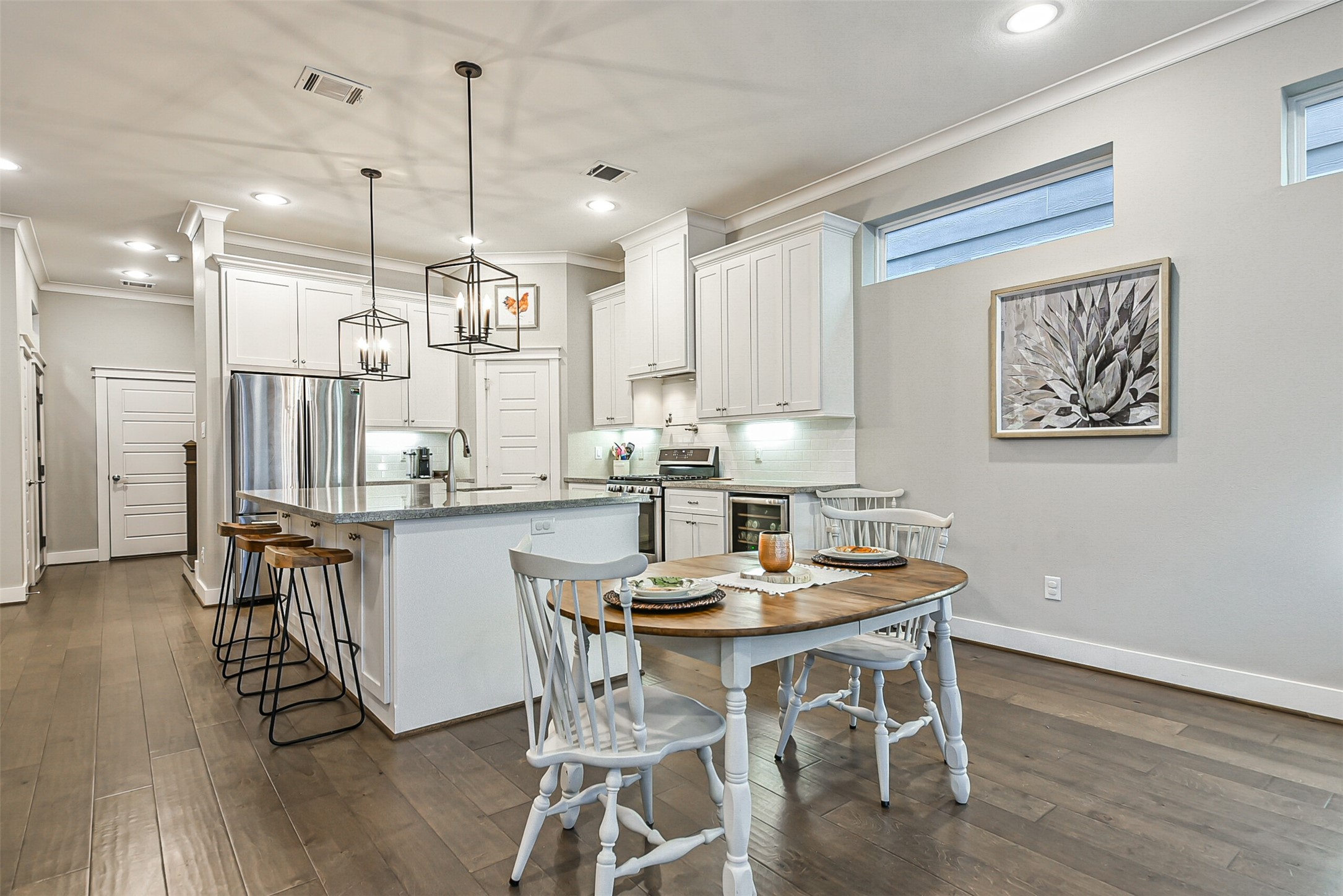 3222 Gillespie Street Houston, TX 77020 - Photo 17 of 43 a kitchen with stainless steel appliances kitchen island wooden floors and white cabinets